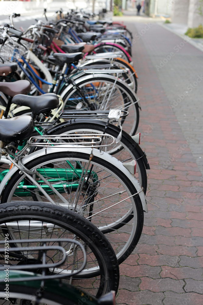 A group of bicycles lined up in a row on the sidewalk.