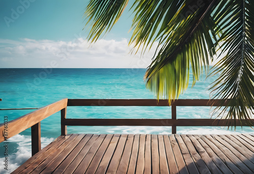 A serene ocean view from a wooden deck shaded by palm leaves, with clear blue skies and turquoise waters.