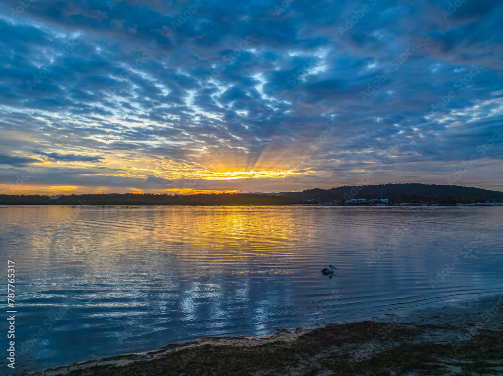 Naklejka premium Sunrise over the bay water with clouds and reflections