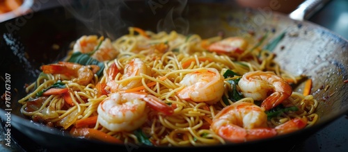 Noodles accompanied by shrimp and vegetables.