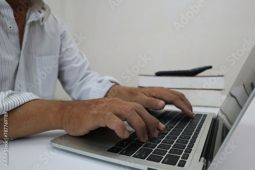 businessman hands searching for data on Notebook with analyzing charts at his workplace.