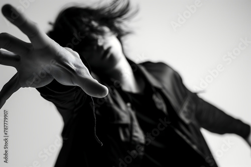 Monochrome shot of a man extending his hand, hair in motion.