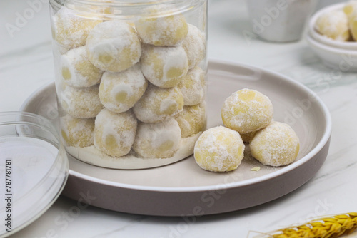 Kue putri salju or snow white cookies, popular hari raya cookies in Indonesia, baked and powdered with icing sugar. Special background for ramadan and eid mubarak.  photo