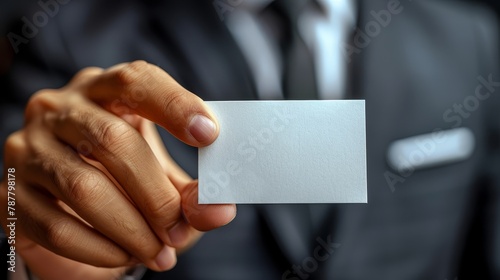  A man in a suit holds one business card in each hand