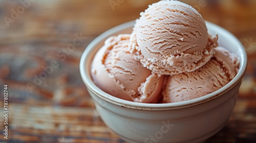   Three scoops of ice cream in a bowl on a wooden table