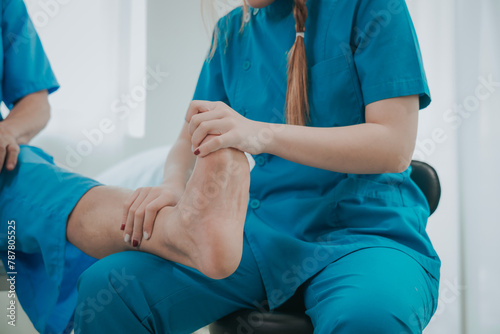 Asian female physical therapist helps an elderly man stretch his Achilles tendon  physical therapy rehabilitation  elderly. Causes knee pain  swelling  redness  stiffness of the knee  and a rumbling s