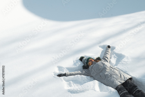 person laying on snow, winter fun