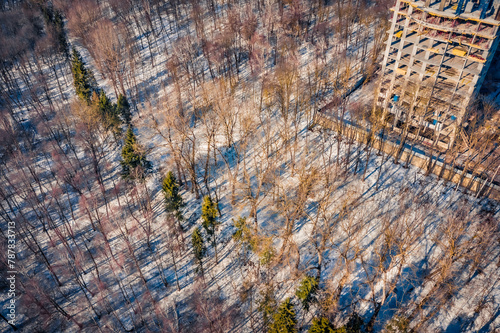 Construction of a high-rise building in early spring. Unfinished construction in the middle of the forest. Aerial morning view of Ternopil cityscape and Zahrebellya city park, Ukraine, Europe. © Andrew Mayovskyy