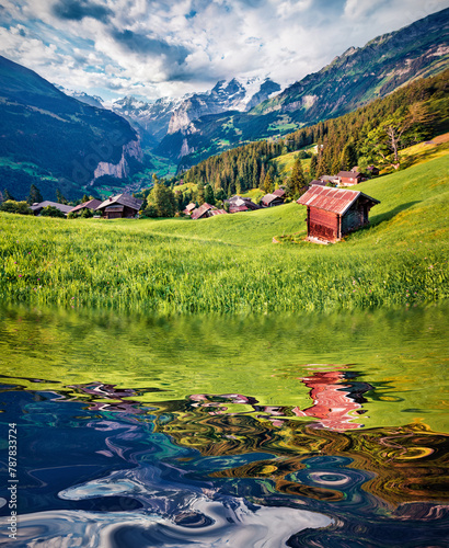 Majestic Swiss countryside reflected in the calm waters of small lake. Green summer scene of Wengen village, Swiss Alps, Bernese Oberland in the canton of Bern, Switzerland, Europe. Travel the world.. © Andrew Mayovskyy