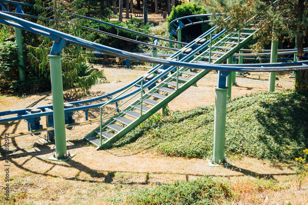 Manège à sensation. Petit train dans un parc d'attraction. Manège à vitesse. Rails élevées pour un train. Rails en hauteur. Rampe et ascension d'un manège. Fête foraine dans un milieu naturel. Manège à sensation. Petit train dans un parc d'attraction. Manège à vitesse. Rails élevées pour un train. Rails en hauteur. Rampe et ascension d'un manège. Fête foraine dans un milieu naturel.