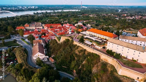 Hyperlapse Timelapse Explore Novi Sad, Serbia from above as a river runs through the city showcasing iconic landmarks like the Petrovaradin Fortress.