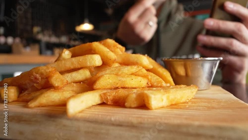 French fries neatly arranged on a rustic wooden cutting board, showcasing a delicious snack or side dish.