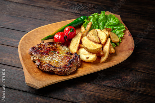 Pork or beef steak with arena potatoes on dark boards background. Menu for a pub