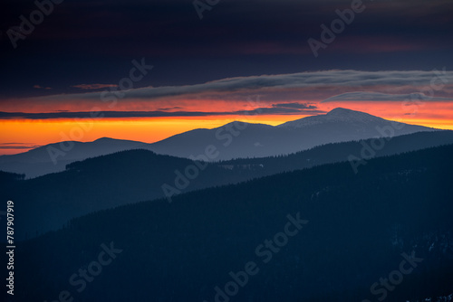 Dramatic sunrise in Beskids Mountains. View from Rysianka mountain to Babia Gora peak on the fire red sky