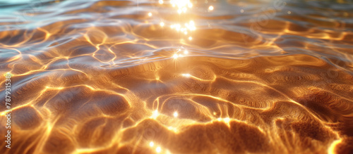 Sunlit water surface creating sparkling ripples over sandy bottom. Close-up of shimmering sunlight on clear water above sand texture © Denniro