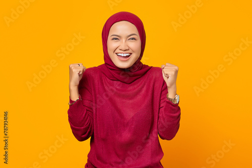 Excited Asian muslim woman celebrating victory smiling looking a © Bangun Stock Photo