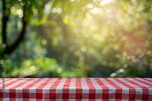 Top view of red checkered tablecloth with green bokeh background ideal for product display or summer design layout