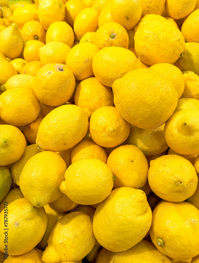 Yellow lemons on a counter in a market as an abstract background. Texture