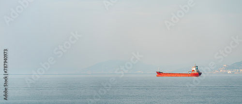 Orange general cargo ship anchored off the coast of Alanya, Antalya photo