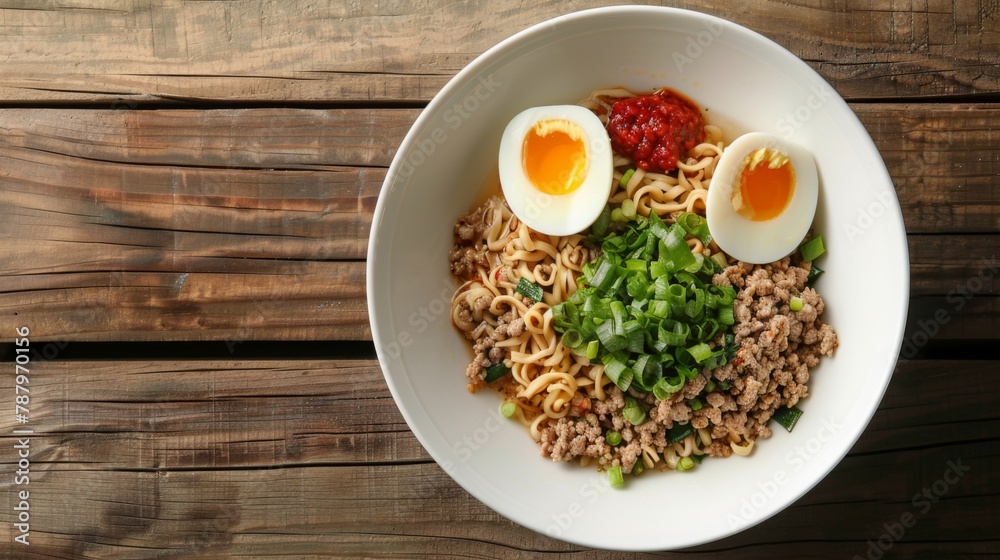 Top view of instant noodle soup with minced pork and half boiled egg in white bowl on wooden table background. Asia Food Top view of instant noodle soup with minced pork and half boiled egg in white bowl on wooden table background. Asia Food