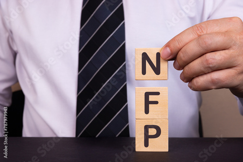 Man made word, text Business Acronym NFP as Not For Profit with wood blocks. Concept. photo