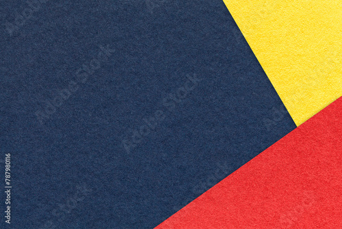 Texture of craft navy blue color paper background with yellow and red border. Vintage abstract denim cardboard. © nikol85