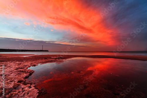 Dramatic red sunset over rocky coastline and entrance to port of Klaipeda, Lithuania photo