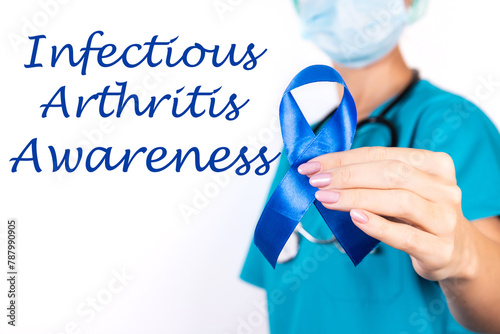 Infectious Artritis awareness concept. A doctor in blue clothes with a blue ribbon in her hand, as a symbol of awareness. photo