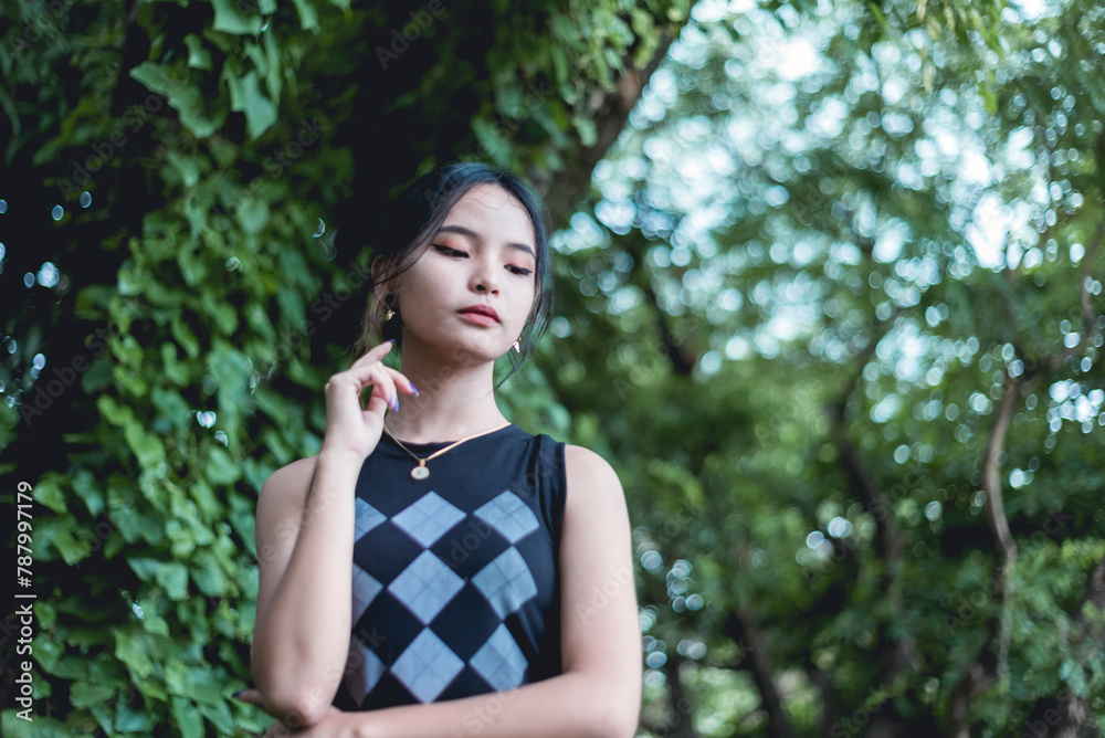 Contemplative young Asian woman in fashionable black outfit outdoors Contemplative young Asian woman in fashionable black outfit outdoors
