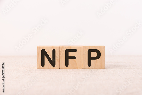 Word Acronym NFP as Not For Profit is made of wooden building blocks. Concept.
