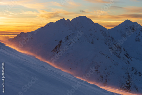 Winter mountain panorama landscape at sunset, West Tatras. View from Volovec to the Rohace. Colorful sky and illuminated by the sun snow blown away by the wind © Marcin Mucharski
