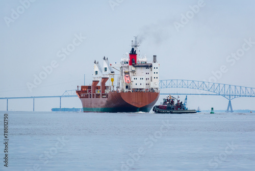 Tug boat escorts ship towards Key Bridge, Baltimore photo