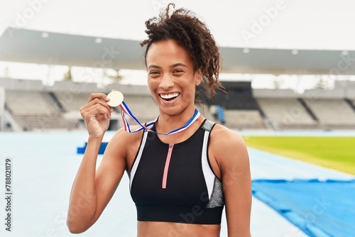 Portrait, winner and athlete with gold medal, sports and stadium for competition. Victory, racetrack or celebration for sprinter and award on field, athletics or cardio event for female runner person © peopleimages.com