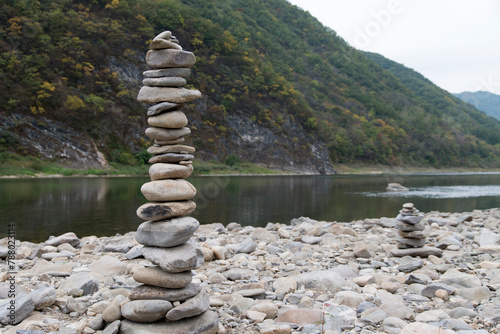 Obraz na płótnie The tower of the stacked pebbles at the riverside w salonie