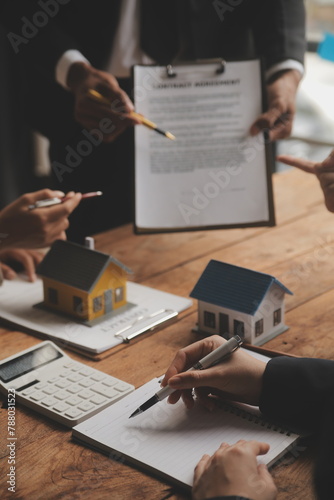 Real estate agent and Sales manager team analysis pricing of rental lease contract of sale purchase agreement, concerning mortgage loan offer for and house insurance. © Sutthicha