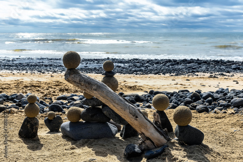 Pretty pile of wooden pebbles and balls of sand facing the sea