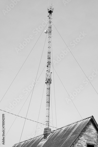 Roof of an old abandoned building and communications tower against sky	