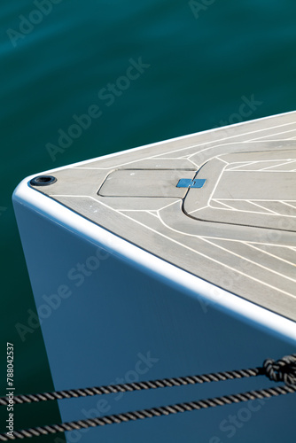 The bow of a beautiful powerboat with nice clean lines showing the deck and hatch.