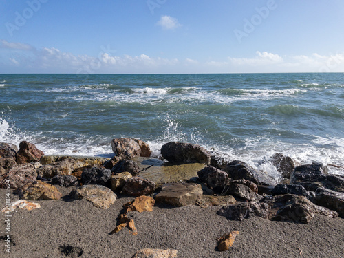 Veduta marina, scogli e onde che si frangono sulla spiaggia in primavera