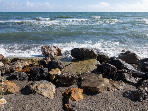 Veduta marina, scogli e onde che si frangono sulla spiaggia in primavera photo