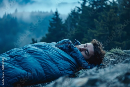 Man sleeping in mountains in sleeping bag photo