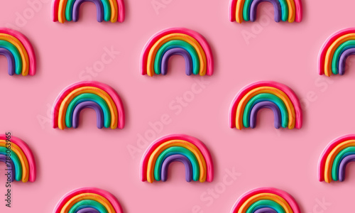 Seamless pattern with rows of multicolored rainbows made with soft foam standing against pink background. Creative and trendy concept. 3d style print