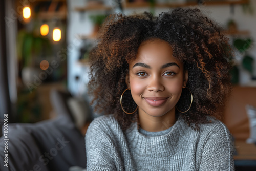 portrait of a black woman with curly hair, big earrings, wearing a thick sweater photo