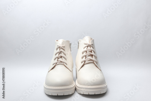 Women's white leather winter boots on white background.