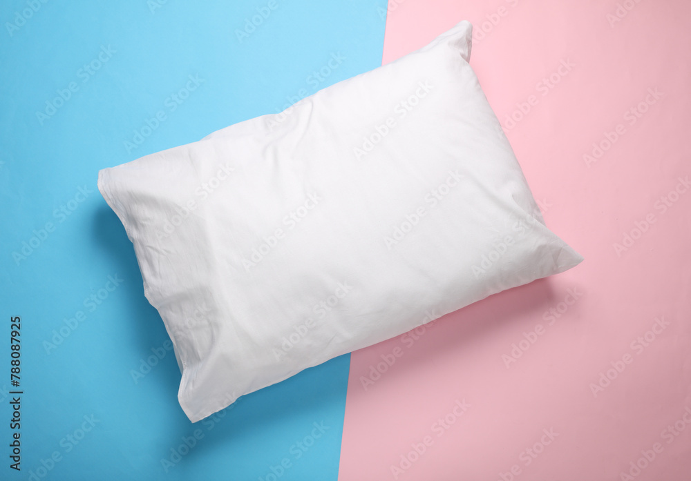 White pillow on a blue-pink pastel background. Top view