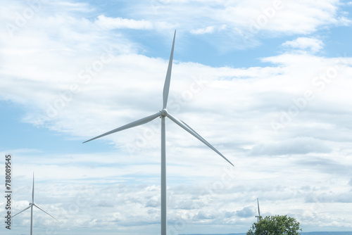 Wind turbines on a hill under a blue sky