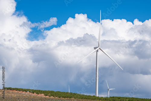 Wind turbines on a hill under a blue sky