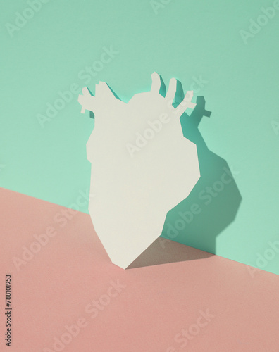 Paper-cut anatomical heart on blue-pink pastel background. Creative layout