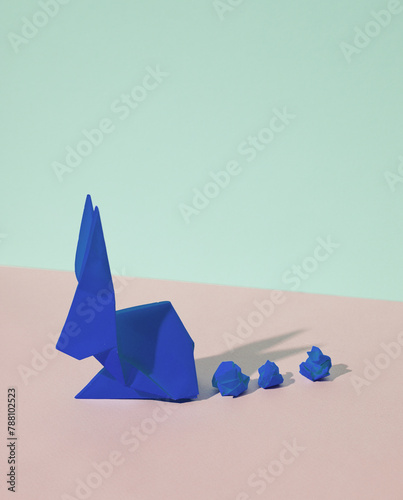 Origami rabbit on a blue-pink pastel background. Creative minimal layout.