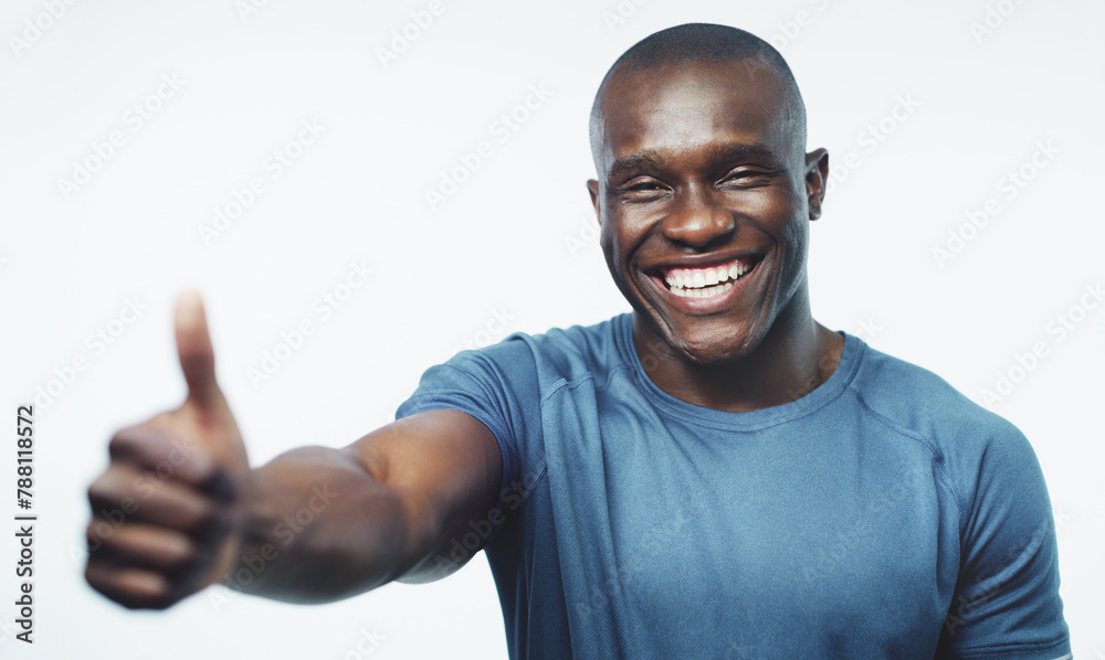 Naklejka premium Thumbs up, fitness and portrait of black man on a white background for training, workout and exercise. Sports, emoji and happy person trainer for gym promotion, subscription and wellness in studio